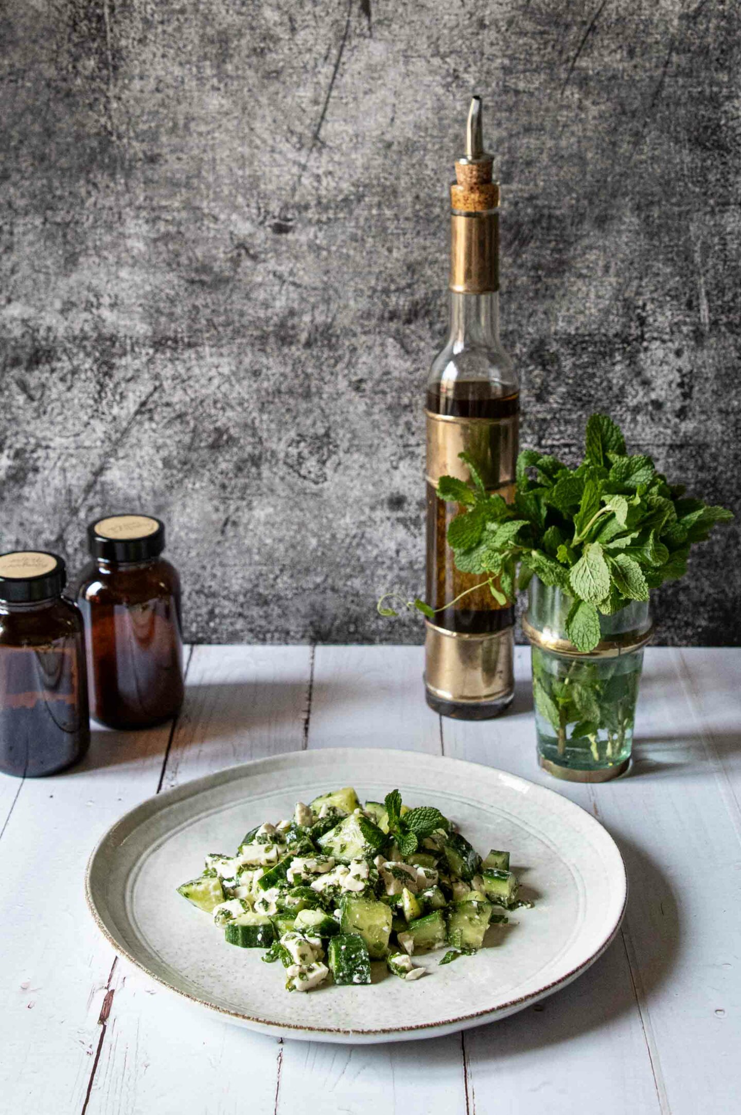 Makrofreundlicher Gurken-Minz-Salat mit Zitronendressing und frischer Minze im Hintergrund.