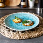 Knusprige Kürbis-Rösti mit Avocado und Hüttenkäse auf blauem Teller, ideal für Makro-Tracking.