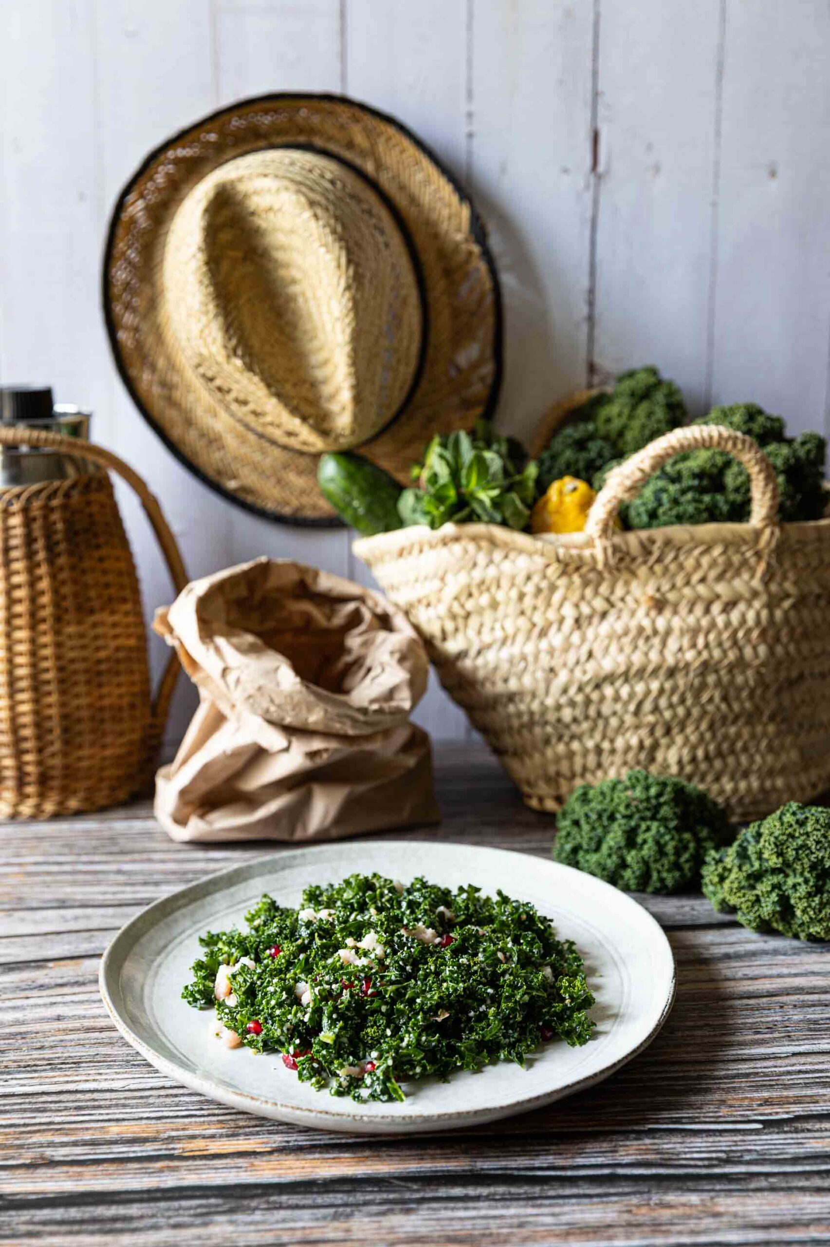 Grünkohl-Salat mit Granatapfelkernen und Parmesan vor rustikalen Körben und Dekoration