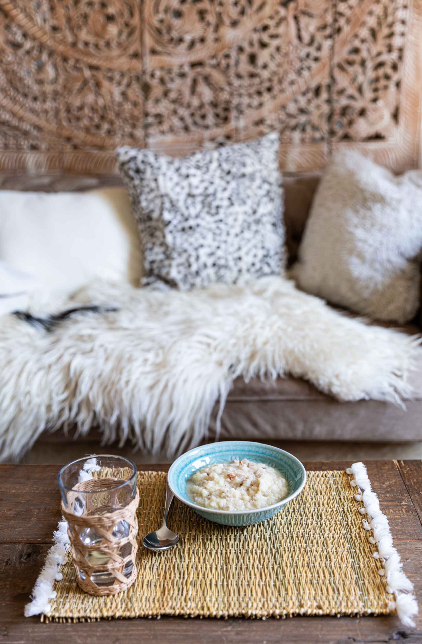 Schale Buttermilchkartoffeln mit Wasserglas und Couch im Hintergrund.