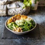 Low Carb Bowl mit Hähnchen, Salat, Gurken, Kichererbsen und Koriander-Limetten-Sauce.