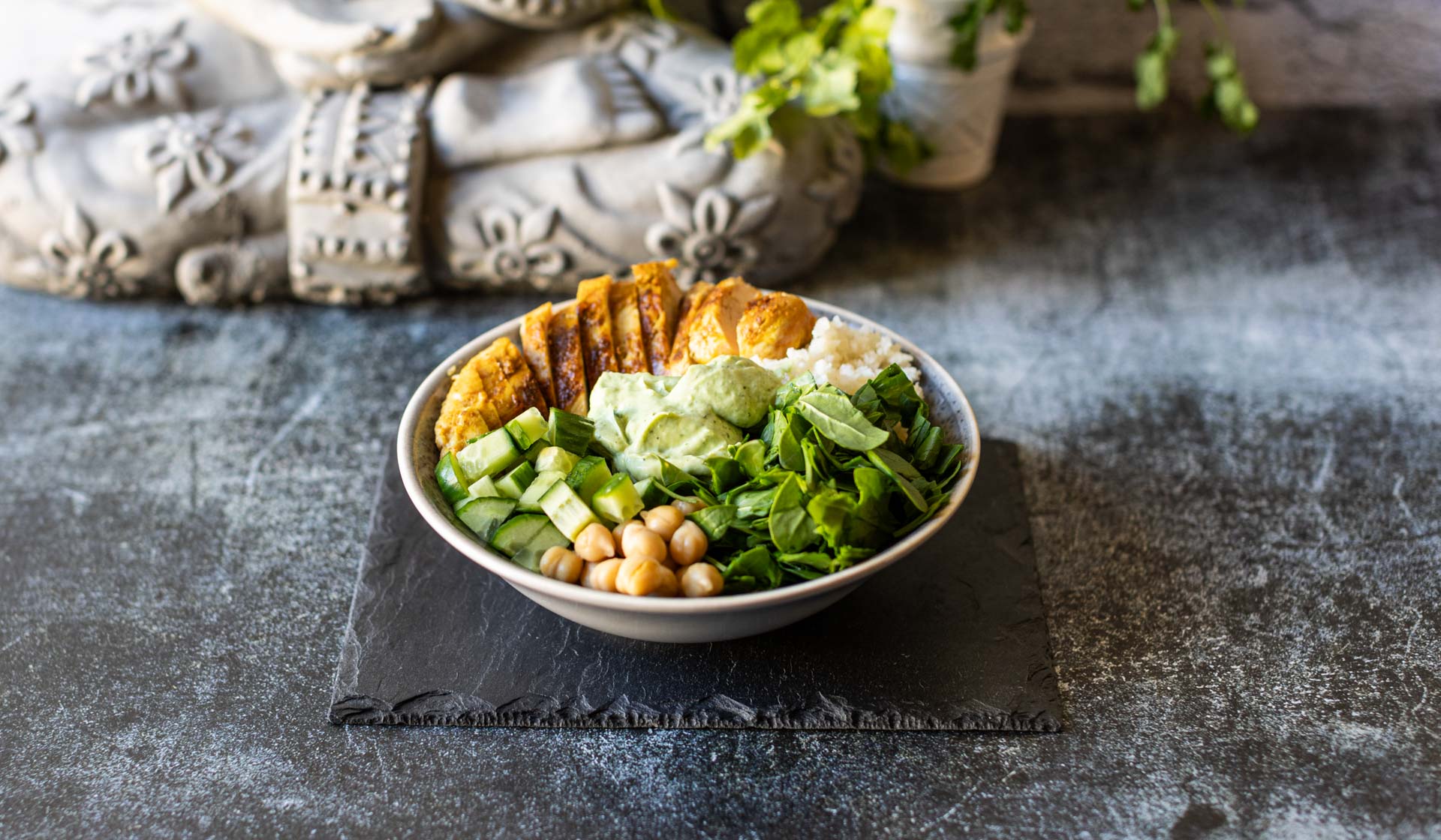 Low Carb Bowl mit Hähnchen, Salat, Gurken, Kichererbsen und Koriander-Limetten-Sauce.