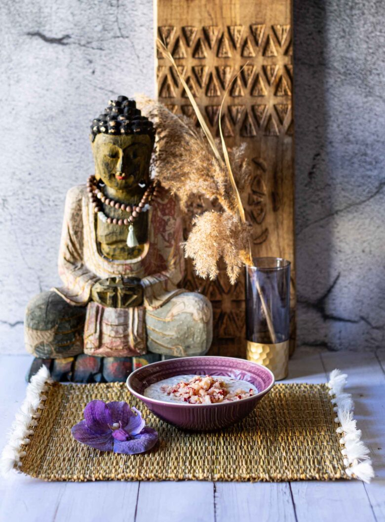 Overnight Oats im Bircher-Müsli Style in Schale vor Buddha-Deko.